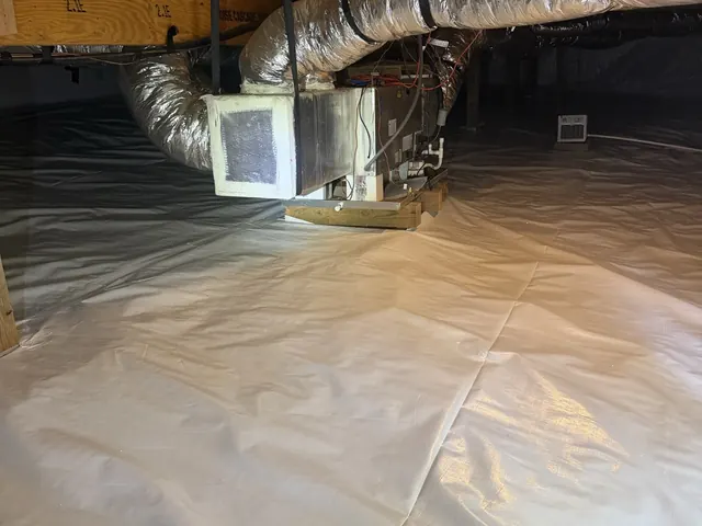 The air handler on a finished white liner after Crawl Space Doctors sealed the space