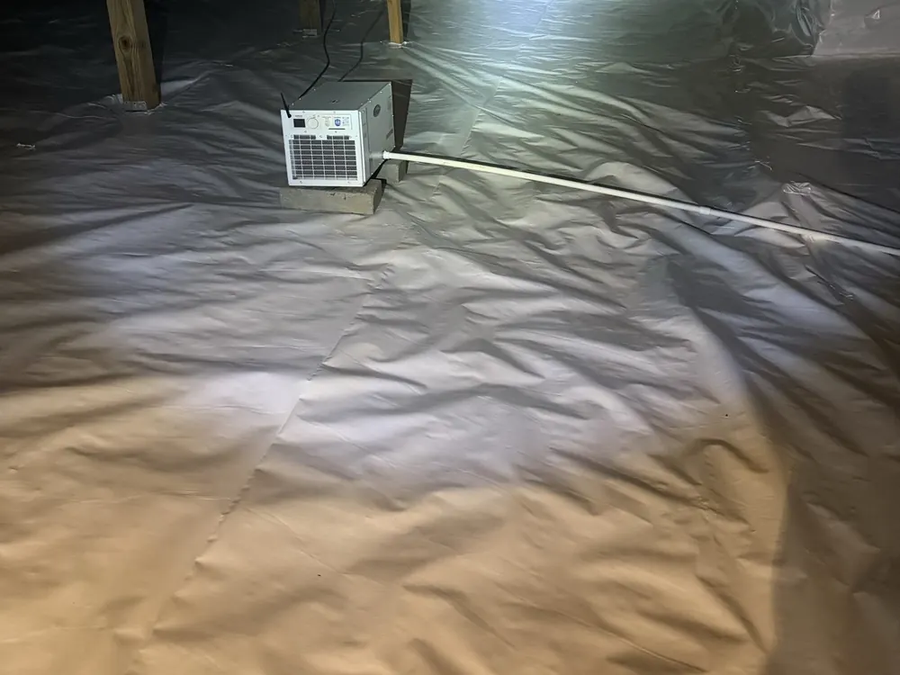 A crawl space dehumidifier running on a finished white liner
