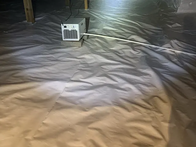 A crawl space dehumidifier running on a finished white liner