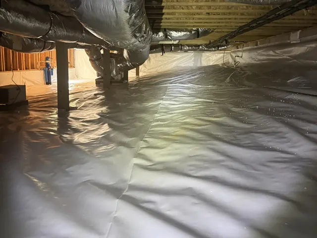 A finished white crawl space liner under the ductwork