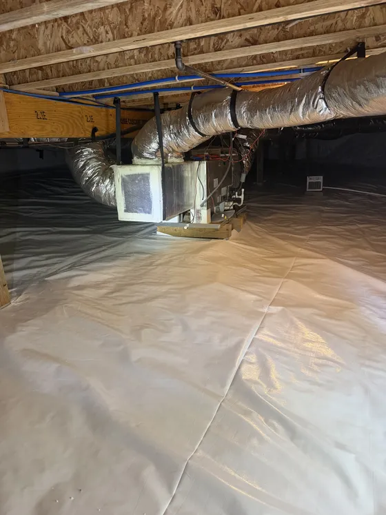 After: the same air handler with a white vapor barrier sealed around it