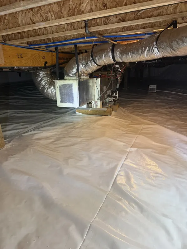 After: the same air handler over a sealed white crawl space liner