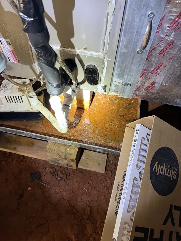 A dehumidifier being installed on a crawl space floor, with its drain line connected, from one of our jobs