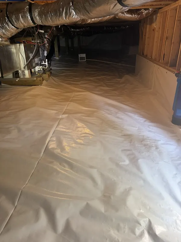 White crawl space liner run up a foundation wall, from one of our jobs